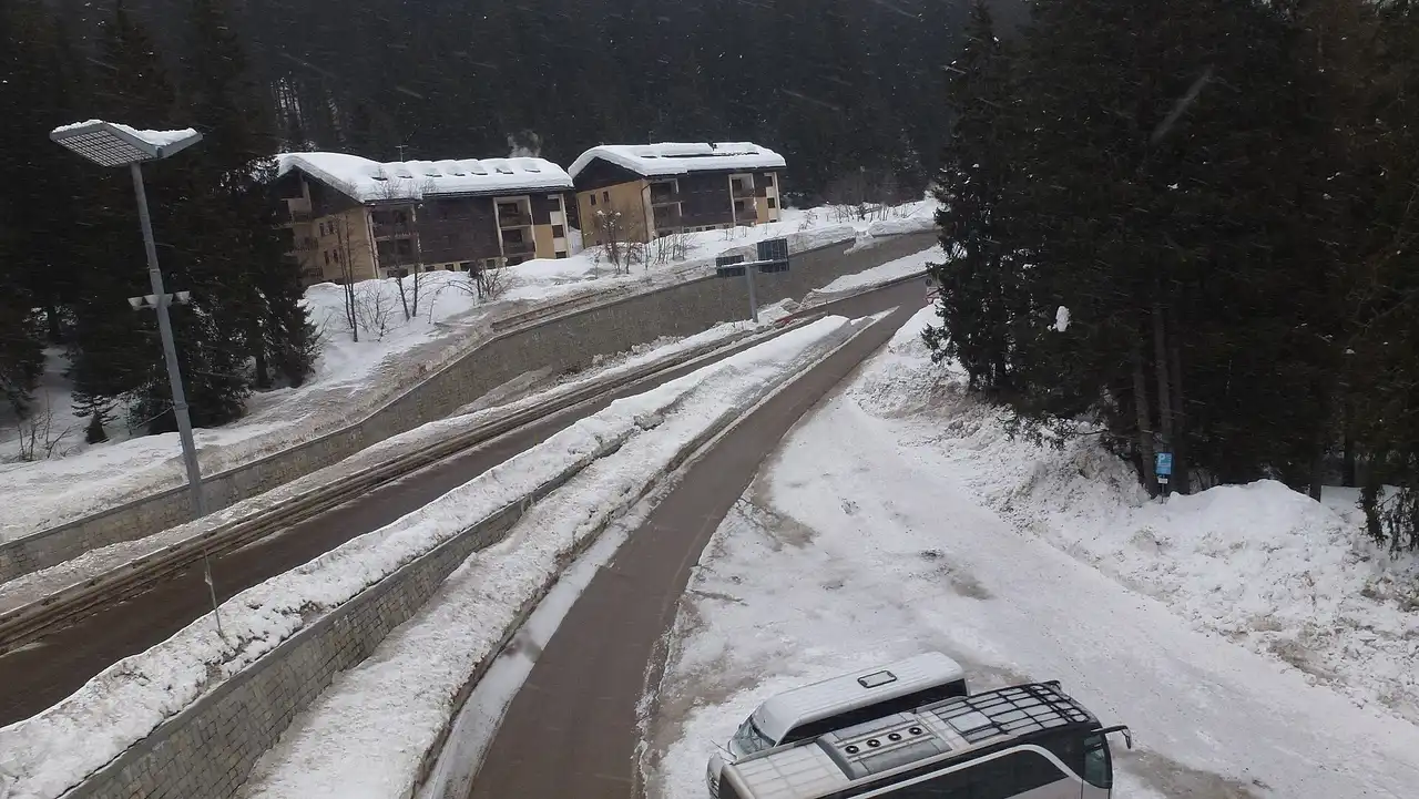 La strada innevata del Passo Campo Carlo Magno con le baite sotto la neve