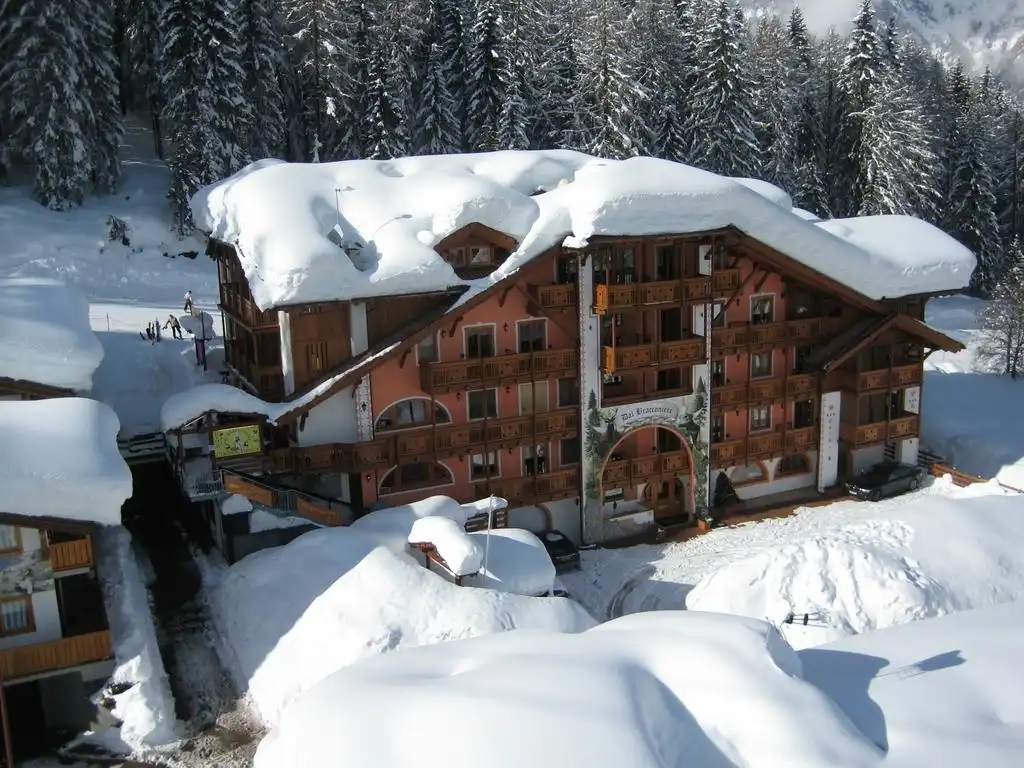 L'Hotel Dal Bracconiere e i boschi di Folgarida coperti di neve dopo una nevicata